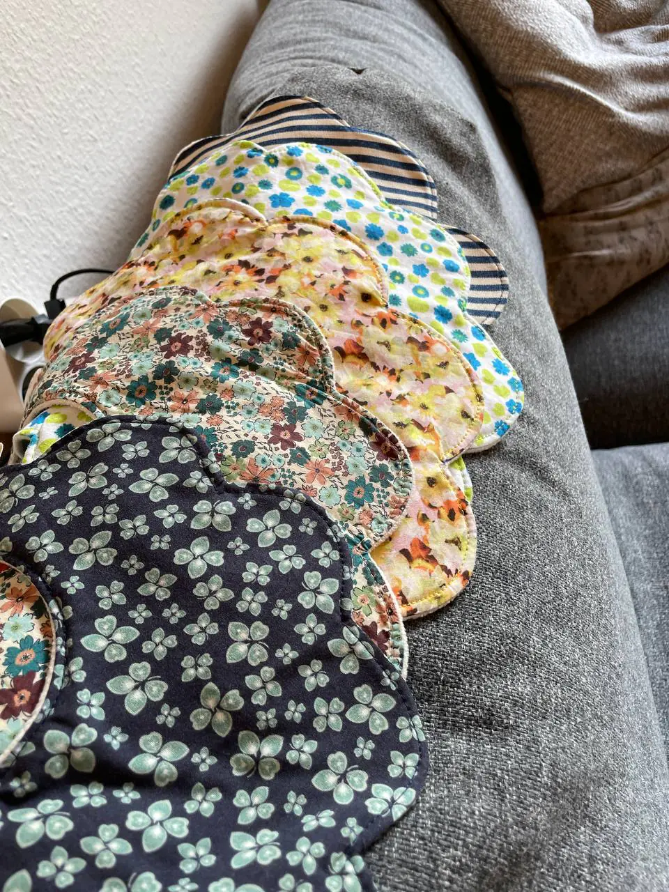 A stack of flower bibs over the arm of the sofa