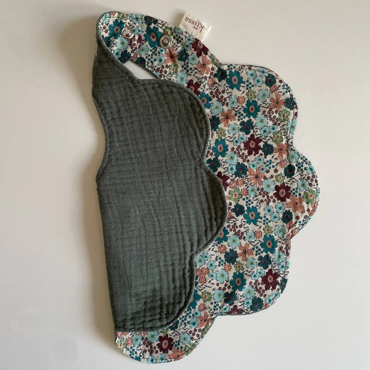 The sage muslin reverse of a Kiissa bib, soft and textured